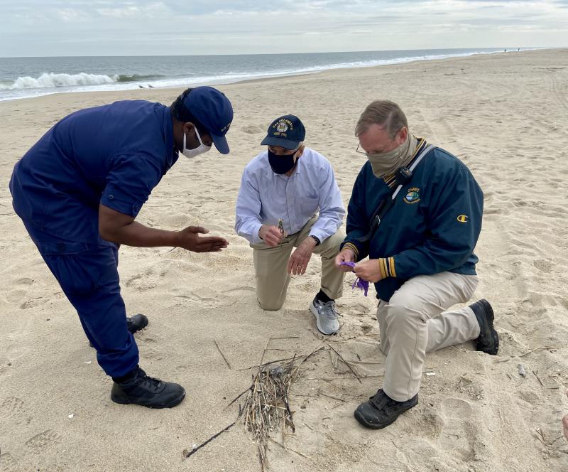U.S. Coast Guard Lt. Cmdr. Fredrick Pugh, left, and DNREC Emergency Prevention and Response Chief Jamie Bethard, right, brief U.S. Sen. Tom Carper on the oil spill cleanup efforts Oct. 27 at Tower Road Beach. The spill was first reported in Broadkill Beach Oct. 19, officials said. ELLEN DRISCOLL PHOTOS